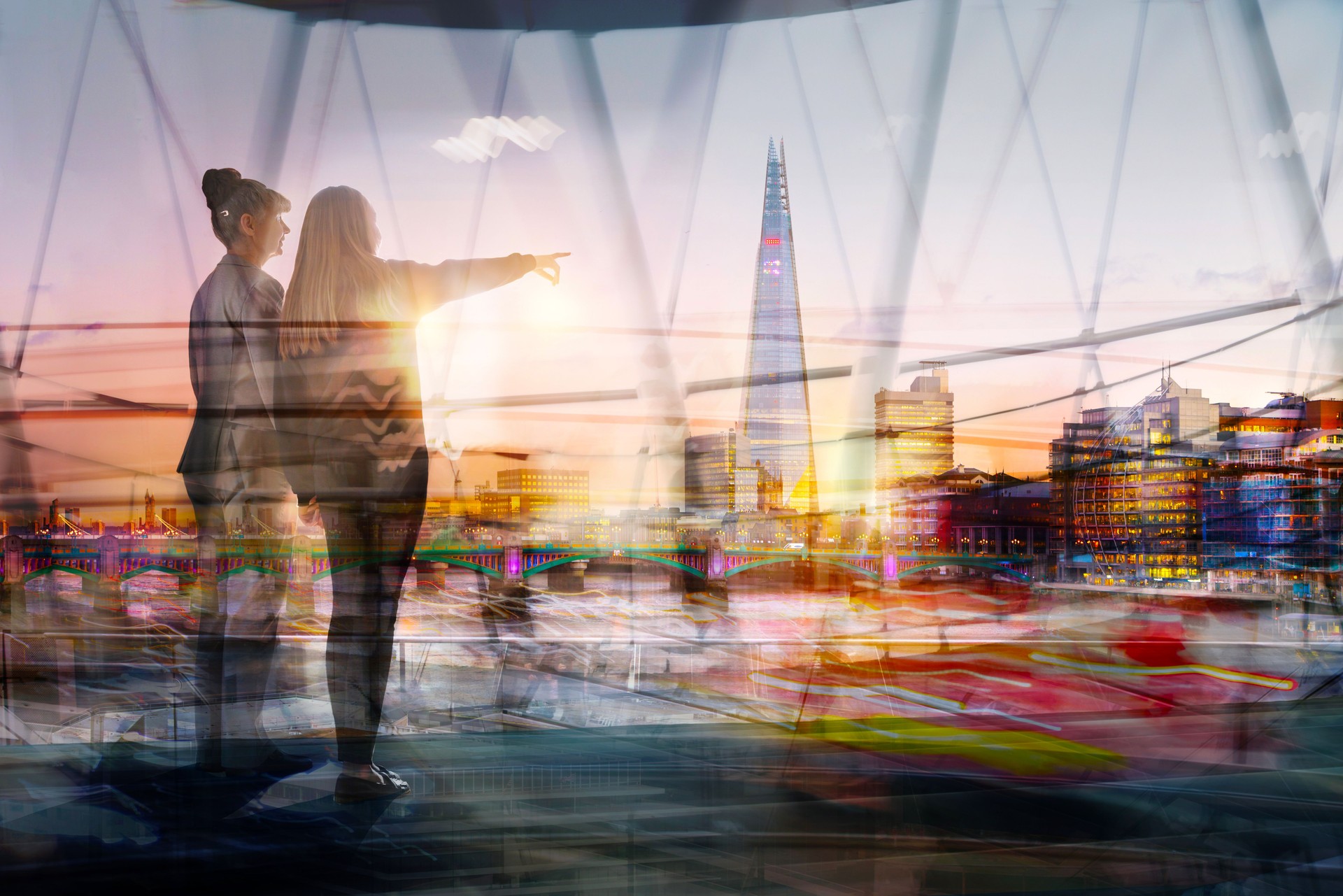 Two woman, younger and elder looking over the  City of London at sunset. Future, new opportunity, freedom and travelling concept. Two generations. London, UK